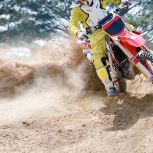 man riding dirtbike on racetrack